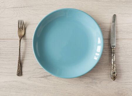 empty blue dishes (plate, bowl) on a white wooden background, top view, copy space