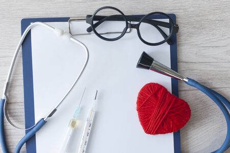 Doctors Day , the cardiologist's day, blue stethoscope with a red heart and blank your clipboard on a background of white boards, diagnosis of heart diseaseの写真素材