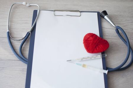 Doctors Day , the cardiologist's day, blue stethoscope with a red heart and blank your clipboard on a background of white boards, diagnosis of heart diseaseの写真素材