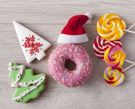Sweets creative lay out, dessert concept with lollipops, and donuts on wood background top view copy spaceの写真素材
