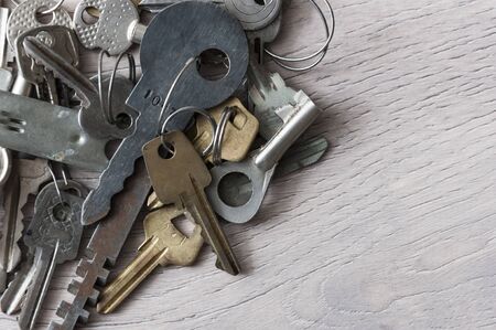 Border of different new and vintage keys and bunches on wooden background. Safety and security...