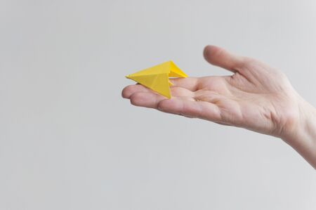 Woman hand throwing paper plane over white backgroundの写真素材