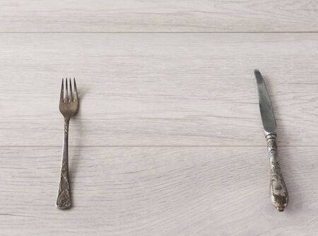Table setting with fork and knife on wooden background