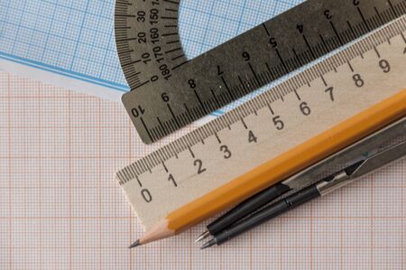 Mathematical instruments over the corner of a math graph paper with copy space for text. Math...