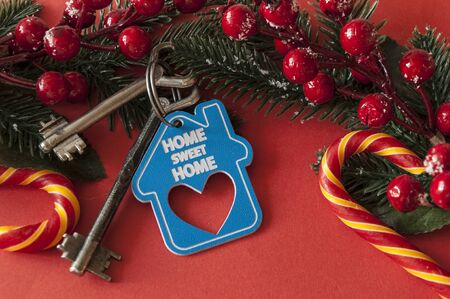 Beautiful Christmas background: decorative house and key to the lock on red background, flat lay....