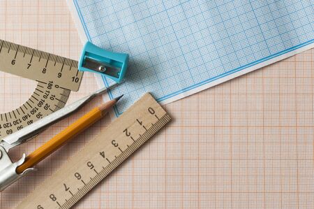 Mathematical instruments over the corner of a math graph paper with copy space for text. Math...