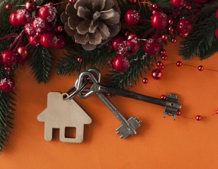 Christmas decorations: decorative house and key to the lock on red paper background, concept of finance and housing loansの写真素材