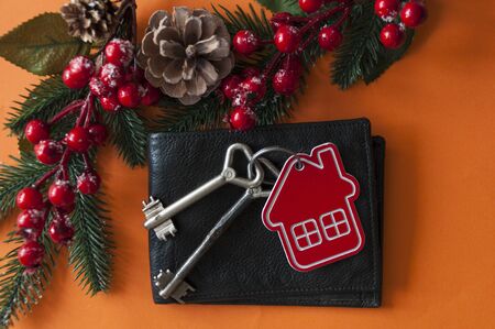 Christmas decorations: decorative house and key to the lock on red paper background, concept of finance and housing loans の写真素材