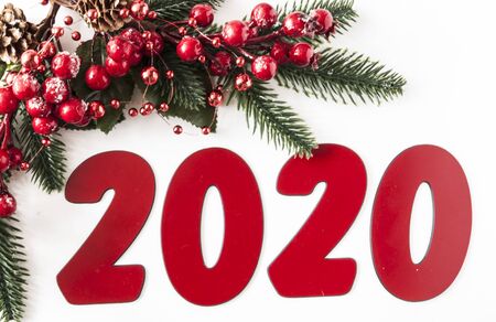 Christmas background with fir twigs, red berries, cones and balls with copy-space on white paper...