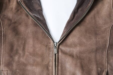 not fully buttoned metal zipper on a leather brown jacket