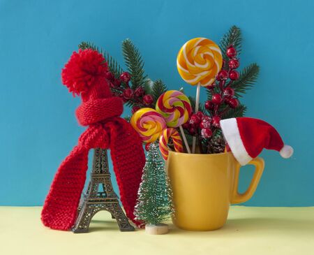 Christmas decoration with  statue in red scarf and hat  on colorful paper background. Holiday background with space for textの写真素材