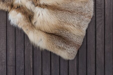 Textures red fox fur. Red fox shaggy fur texture cloth abstract, furry rusty texture plain surface on wooden background. Top view. の写真素材