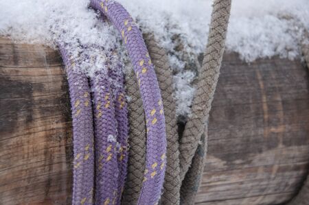 rope covered snow tied around a wooden logの写真素材
