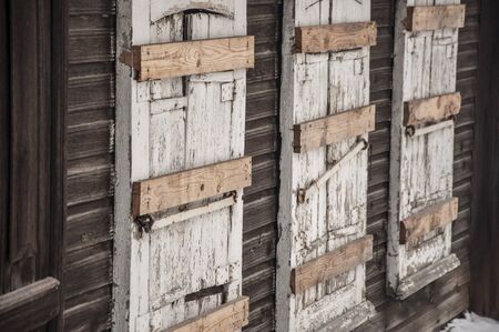 Old window shutters in wooden wall.