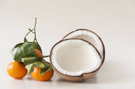 mixed fruit: coconut, fresh apples and mandarins with green leafs. Healty fruits