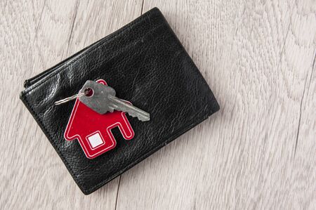 Key home and leather wallet on old wooden table. の写真素材