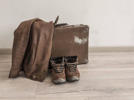 vintage suitcase, leather jacket and boots over white wall backgroundの写真素材