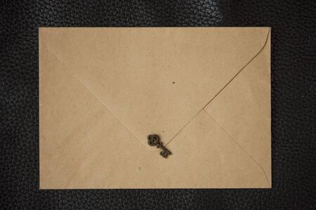 Old envelope with single vintage key. close up, top viewの写真素材