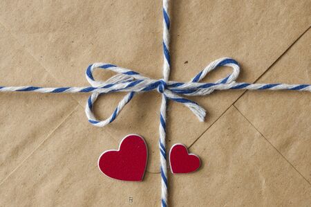 Brown paper envelope tied with a rope and a red hearts . Valentine day card, love or wedding...