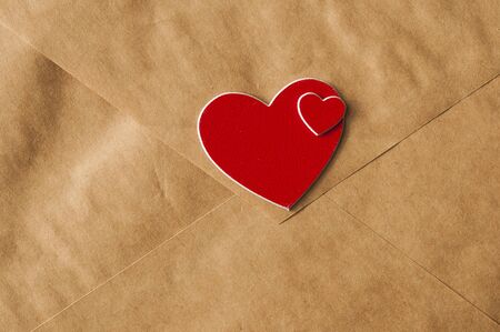 Brown paper envelope tied with a rope and a red hearts . Valentine day card, love or wedding...