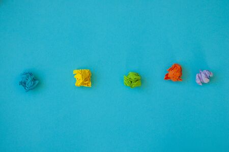 Set of multiple colorful crampled paper ball placed in line as means of searching of new ideas.