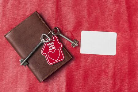 brown leather wallet with house keys on red background. Flat lay, top view, copy space. の写真素材