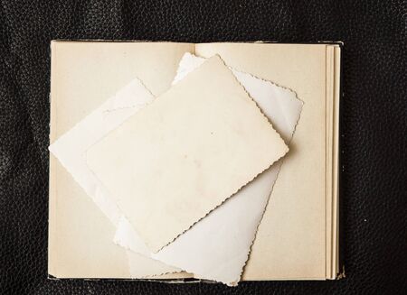 old book with vintage photo on black leather background