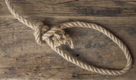 Close-up of a thick hemp rope. Natural rope on an old wooden table. Side view. Soft focus.の写真素材