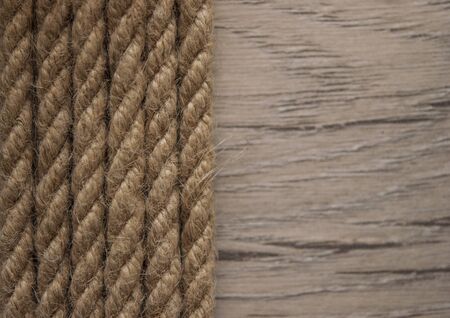 Close-up of a thick hemp rope. Natural rope on an old wooden table. Side view. Soft focus. の写真素材