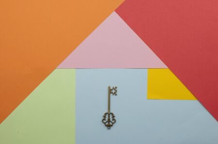 Vintage house key on colorfull paper background concept for real estate, moving home or renting property の写真素材