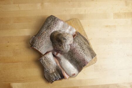 pieces of rainbow fresh trout fish on a wooden surface