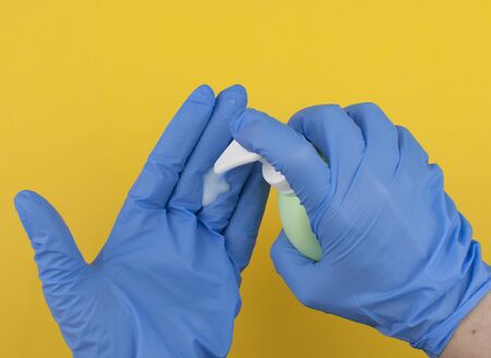 the surgeon sterilizes blue gloves before surgery.