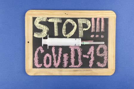 Chalk inscription stop coronavirus covid-19 on blackboard. World pandemic epidemic concept.の写真素材
