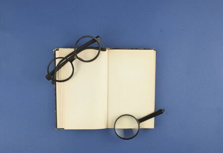 Open old vintage books and glasses. Top view