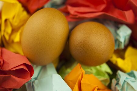 Two brown Easter eggs on crumpled colorful paper. Close-up. Healthy food. Flat lay, top view.