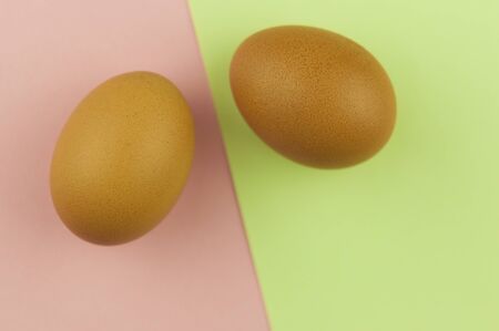 Two brown Easter eggs on color paper background. Close-up. Healthy food. Flat lay, top view.の写真素材