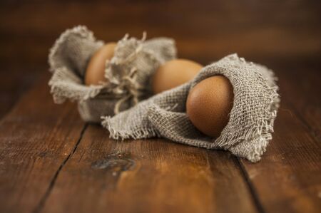 Easter in a rustic, natural style. Flat lay composition of Easter eggs on a background of burlap and wooden plank, space for text. Happy Easter Spring Festive greeting card.の写真素材