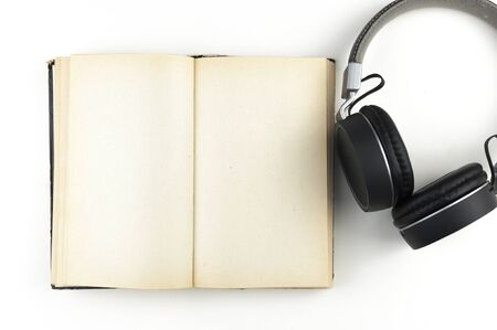 Audio book concept. headphones with book on white background. Listening to book. Modern education.の写真素材