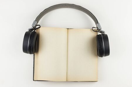 Audio book concept. headphones with book on white background. Listening to book. Modern education.の写真素材