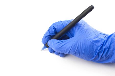 A female hand in a medical glove holds a pen and writes in the air on a white background. Copyspace. の写真素材