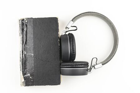 Audio book concept. headphones with book on white background. Listening to book. Modern education.の写真素材