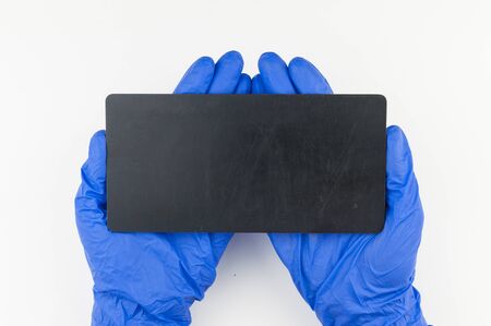 Empty blackboard in doctorâ€™s hands in blue gloves on white background.  copy space for your...