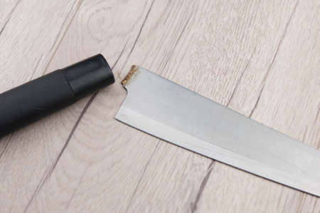 Close up of obsolete damaged broken knife on wooden background