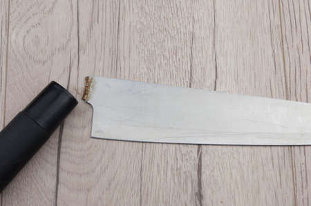 Close up of obsolete damaged broken knife on wooden background