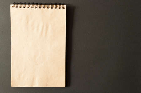 Brown notebook on black paper background