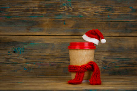 disposable cup for beverages coffee or tea in cardboard holder, knit toy red hat and scarf, new year, Christmasの写真素材
