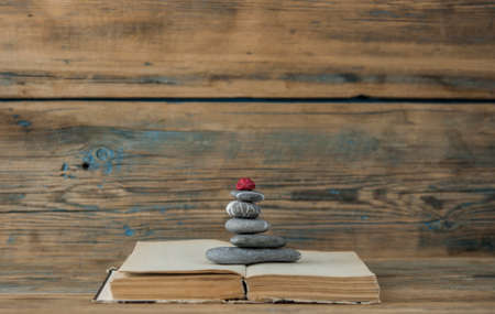 books and stack of zen stones on wood table background. Feng Shui, Balance and relaxation concept.の写真素材
