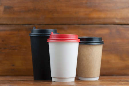 three disposable coffee cup on wood background with copy spaceの写真素材