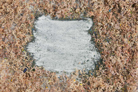 Colorful pencil fragments, tiny pencil shavings on white background. Crayon shavings Artistic...