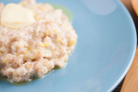 Healthy food classic porridge in blue dish on wood background. oatmeal food breakfast. Top view.